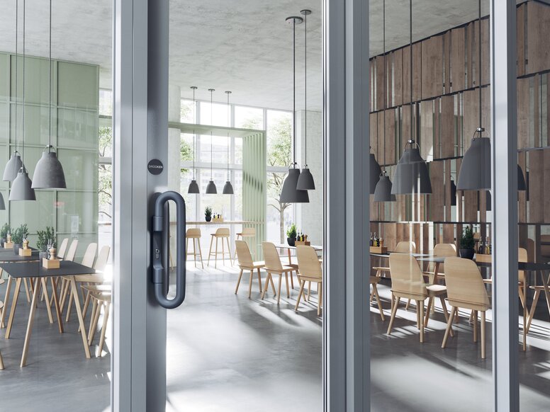 HEWI Push/Pull Handle A dark grey door handle on a double glass door in a catering area