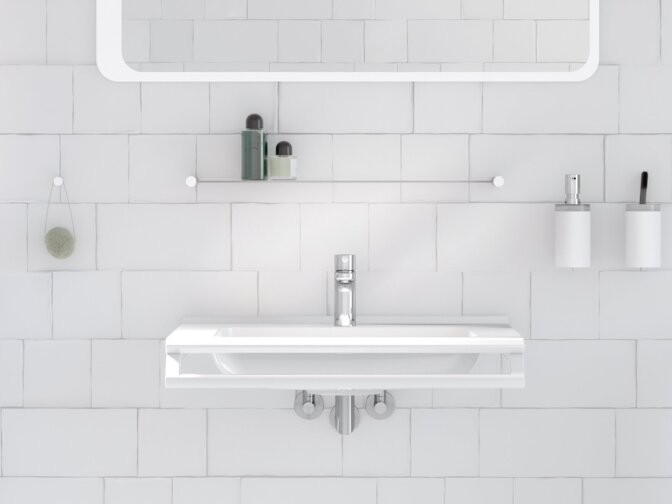 A washbasin with a side-mounted towel holder beneath a rectangular mirror with integrated lighting in the wash area, set against a white tiled wall