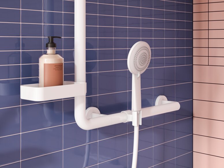 HEWI System 700 shower handrail with shower head holder White shower handrail with a vertical rail and shower head holder, a hand shower and a shelf holding a soap dispenser on a blue tiled wall