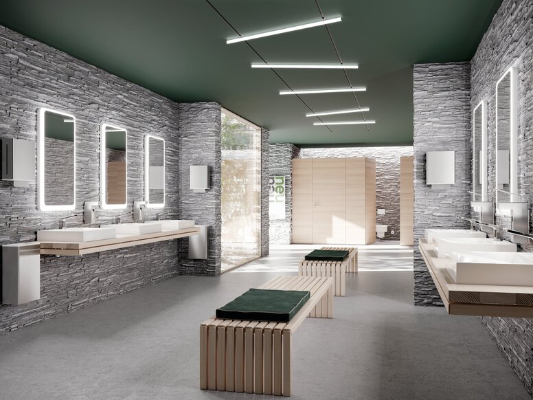 HEWI System 900 Interior Several white washbasins with taps, mounted on two walls, each beneath illuminated mirrors in the public WC