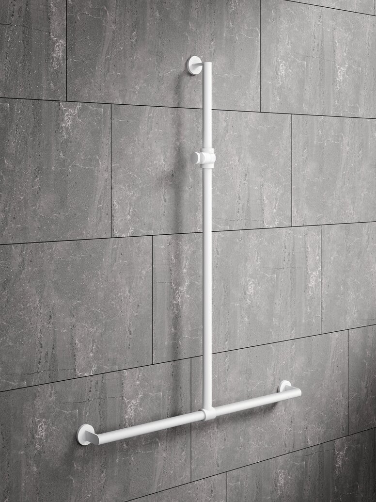 HEWI System 900 rail with shower head holder White powder-coated shower handrail with height adjustment and a horizontal support rail in front of grey stone tiles