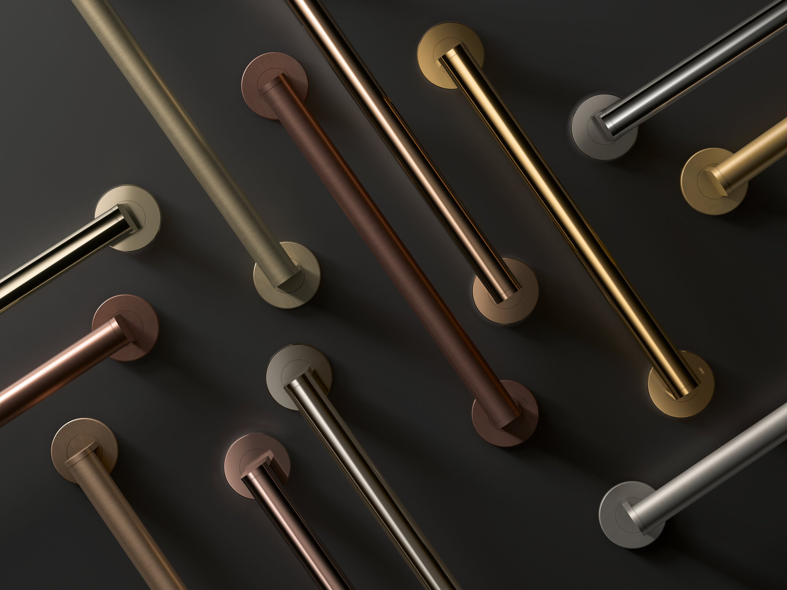 Several diagonally arranged grab rails in different shades of gold, bronze and silver-grey against a dark grey background