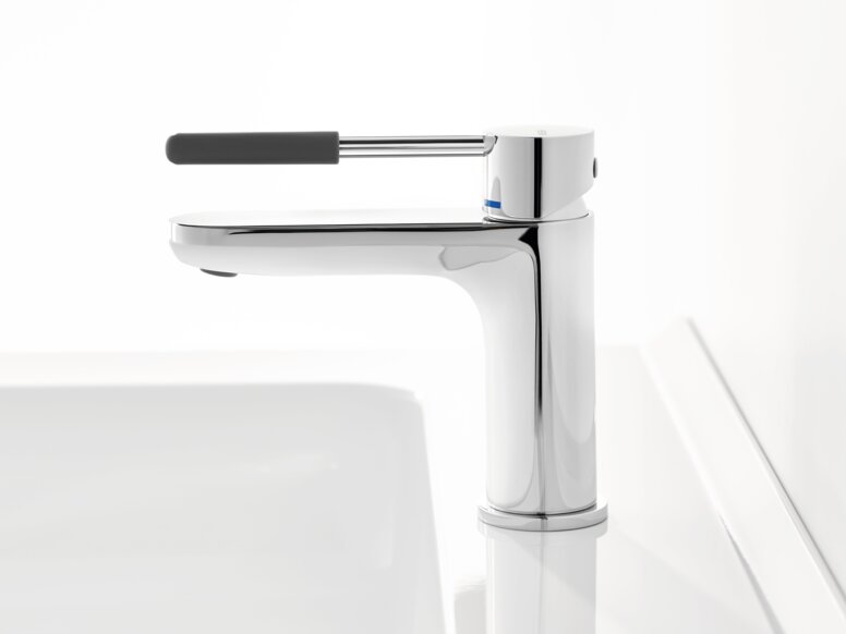 Chrome-plated tap with a long lever handle and dark grey grip sleeve on a white washbasin against a white background