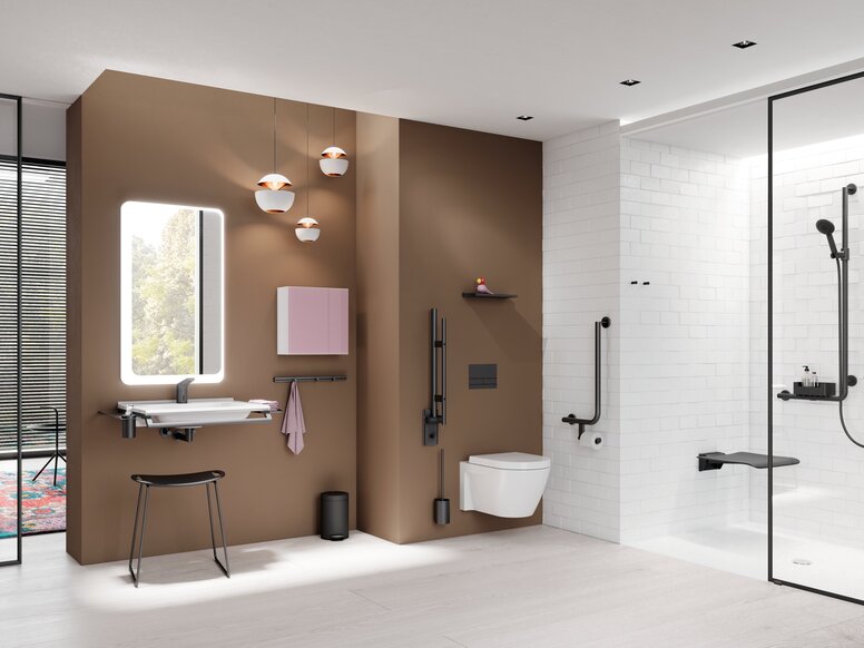 Modern bathroom with a wall-hung toilet against a brown feature wall, a washbasin with an illuminated mirror and stool on the left, and a level-access shower with a glass partition and dark grab rails on the right